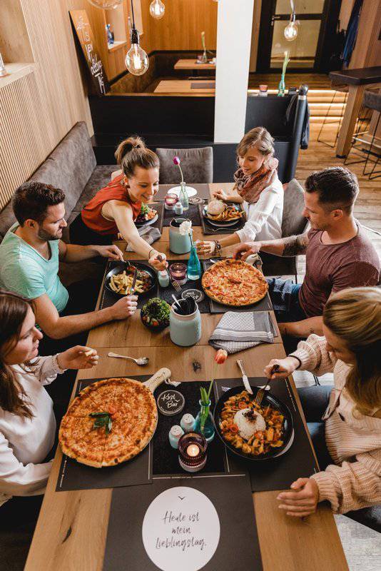 Freunde beim Essen an einem großen Tisch